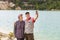 Mature sports couple hikers make selfie with smartphone on the background of azure lake