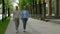 Mature sporty couple holding hands while walking together in the street. Rear view of romantic senior couple resting