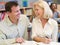 Mature student laughing with tutor in library