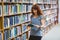 Mature student reading book in library wearing smart watch