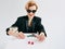 Mature stylish woman in black tuxedo and sunglasses with dices in casino. Gambling, fashion, hobby concept.