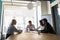 Mature team leader holding briefing with diverse employees in boardroom