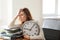 Mature tired woman with clock at table in office. Time management concept