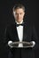 Mature Waiter In Tuxedo Looking At Serving Tray