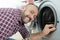 mature washing machine repairman inspecting seal around door