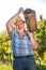 Mature winegrower harvesting black grapes