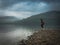 Mature woman with bare feet in the morning on the lake. Travel E