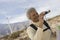 Mature Woman With Binoculars At Wind Farm