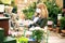 Mature woman buying plants while wearing face mask in the garden store