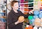 Mature woman choosing colorful yarn in shop