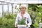 Mature Woman Choosing Plants At Garden Center