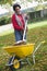 Mature woman collecting leaves in garden