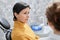 Mature woman in dental chair listening to dentist during consultation in clinic