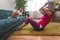 Mature woman doing abdominal exercise, her ginger cat reaches for the owner