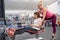 Mature woman doing sport exercises with personal trainer at gym. Female instructor assisting older woman