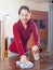 Mature woman dusting wooden table