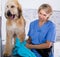 Mature woman hairdresser wipes puppy of Afghan hound in hairdresser for dogs