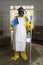 Mature woman in Haz Mat suit with broom and dust pan