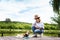 Mature woman and her puppy relaxing together on the pier by the lake