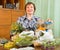 Mature woman with herbs at table