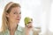 Mature Woman Holding Granny Smith Apple At Home