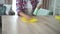 Mature woman household is wiping table with microfiber cloth at home room.