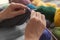 Mature woman knitting warm sweater at table, closeup