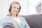 Mature Woman Listening To Music On Wireless Headphones