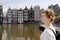 Mature woman looking at the famous dancing houses of Amsterdam on sunny day, Netherlands