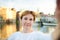 Mature woman making a self portrait selfie with famous dancing houses of Amsterdam on background