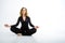 A mature woman of middle age 40 years old practices yoga and sits in a pose for meditation on a white background. Calming thoughts