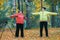 A mature woman performing warm-up in an autumn park after a scandinavian walk