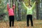 A mature woman performing warm-up in an autumn park after a scandinavian walk