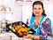 Mature woman preparing chicken at kitchen.