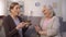 Mature woman presenting birthday cake to her sister, happy lady blowing candle