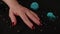 Mature woman's hand with red polish nails on black background with decor. Crop unrecognizable person showing