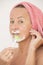 Mature woman shaving face with lotion