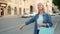 Mature woman with shopping bags waving down taxi in city street smiling