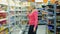 mature woman shopping for milk products at supermarket food department