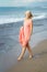 Mature woman on shore of a beach. Elderly female enjoying her retirement at a seaside retreat.