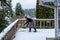 Mature woman shoveling fresh wet snow off a cedar deck, snow day