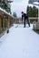 Mature woman shoveling fresh wet snow off a cedar deck, snow day