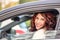 Mature woman smiles driving a car