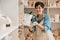 Mature woman smiling and holding ceramic jug at the workshop