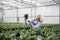 Mature woman standing in greenhouse near plants