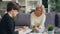 Mature woman talking to female psychologist sitting on couch in modern office