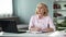 Mature woman thinking with notepad on table, busy housewife, planning of day