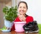 Mature woman transplants potted flower