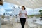 Mature woman walking with cup of coffee in outdoor restaurant resort hotel