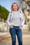 Mature woman walking with fluffy white dog in summer city